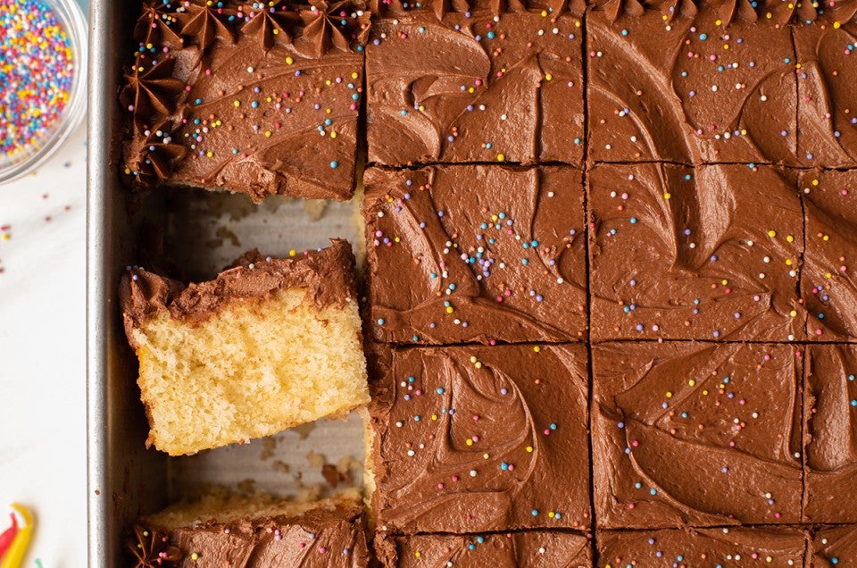 Classic Birthday Cake baked in a sheet pan, sliced and decorated with rainbow sprinkles