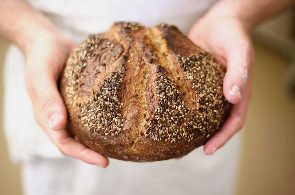 Hands holding seeded loaf