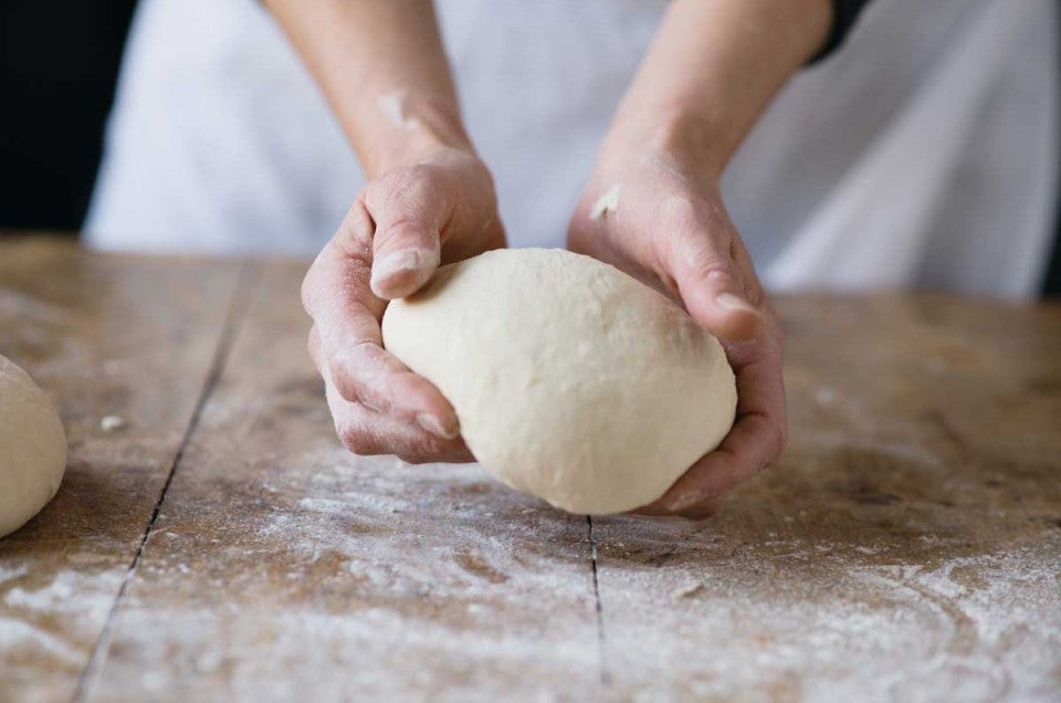 Hand holding bread dough