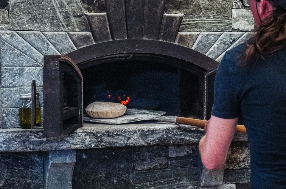 Sliding pita into a wood-fired oven
