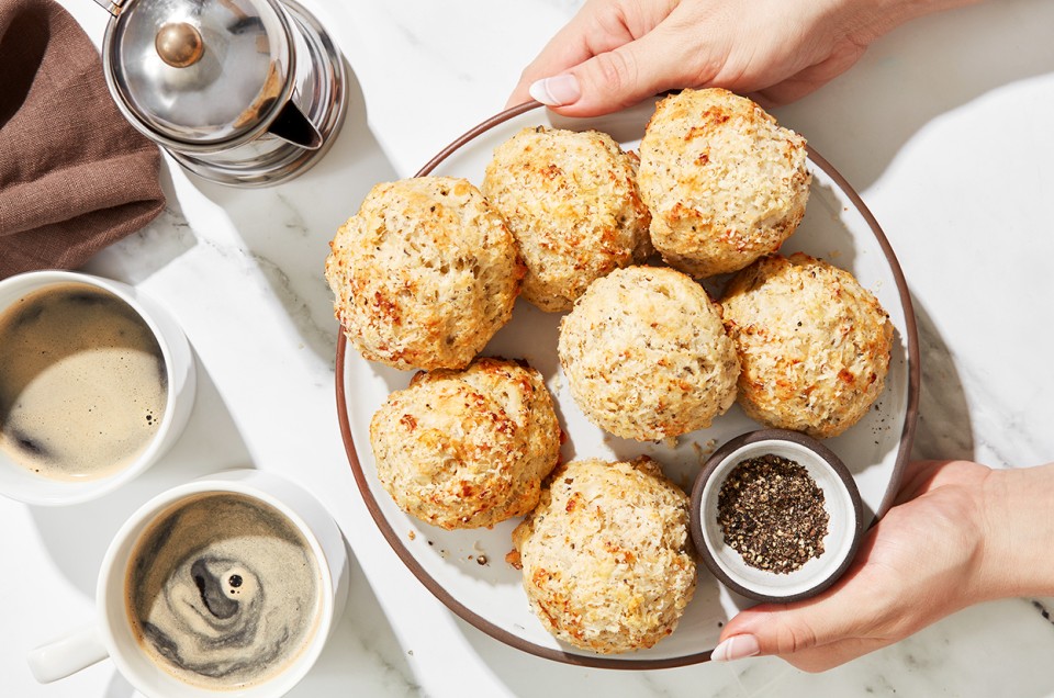 A baker presenting a platter of Cacio e Pepe (Cheese and Pepper) Scones - select to zoom