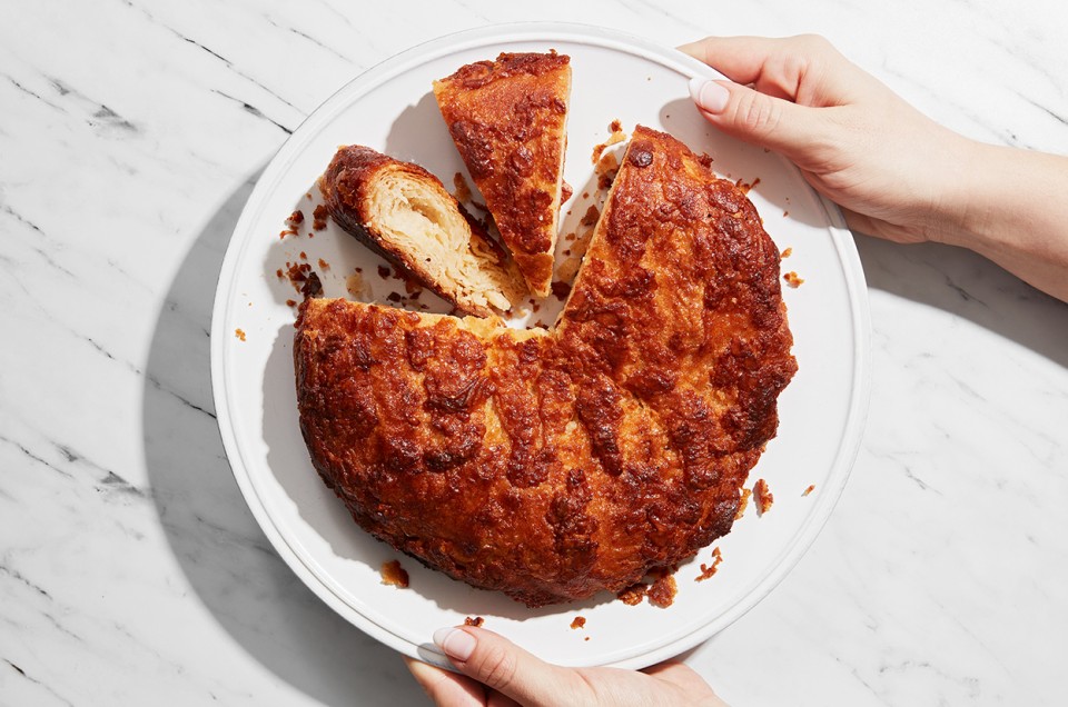 A kouign amann on a plate with a few slices removed