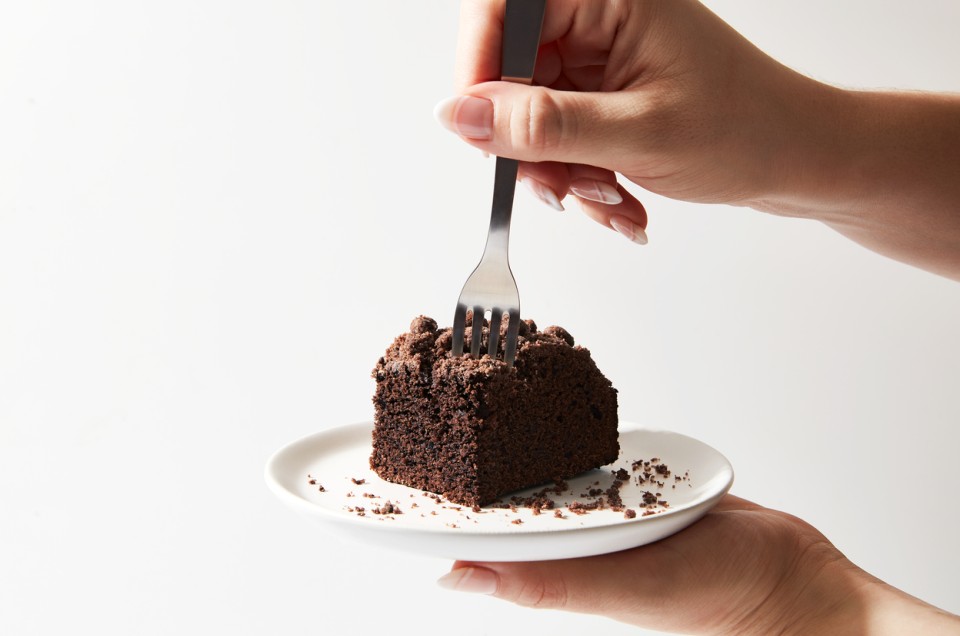 A baker sticking a fork into a slice of rye chocolate coffeecake - select to zoom