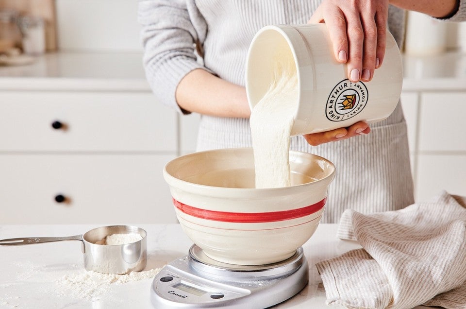 Sourdough starter pouring from a crock