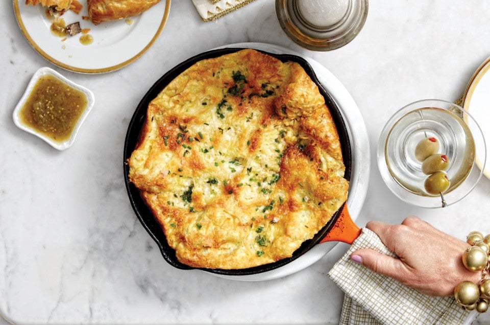 Savory Herbed Parmesan Dutch Baby being served in a cast iron skillet