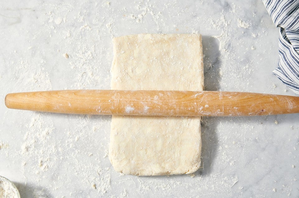 All-Purpose Flaky Pastry Dough underneath a rolling pin - select to zoom