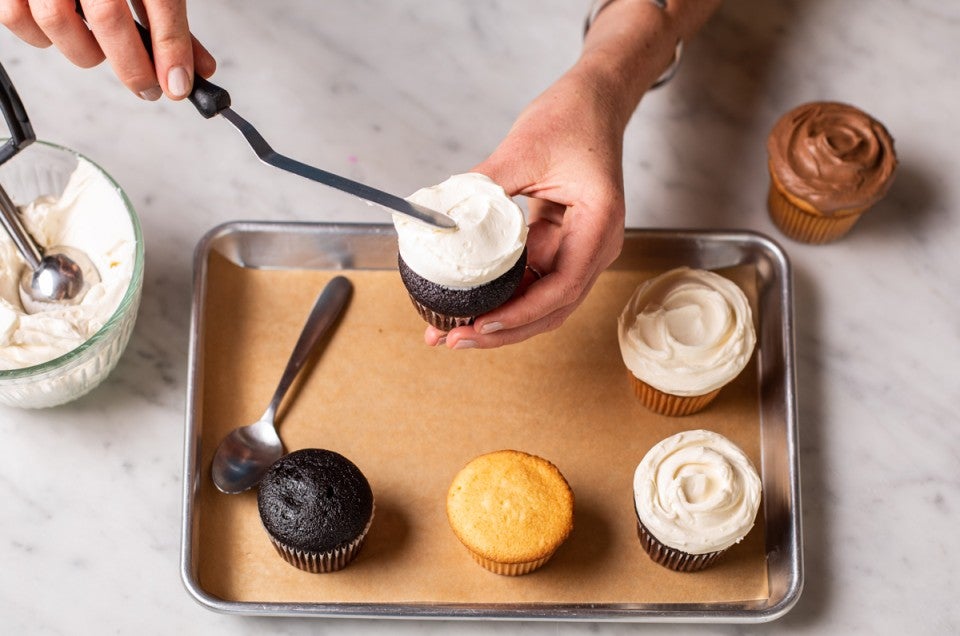 Mini offset spatula being used to frost a cupcake