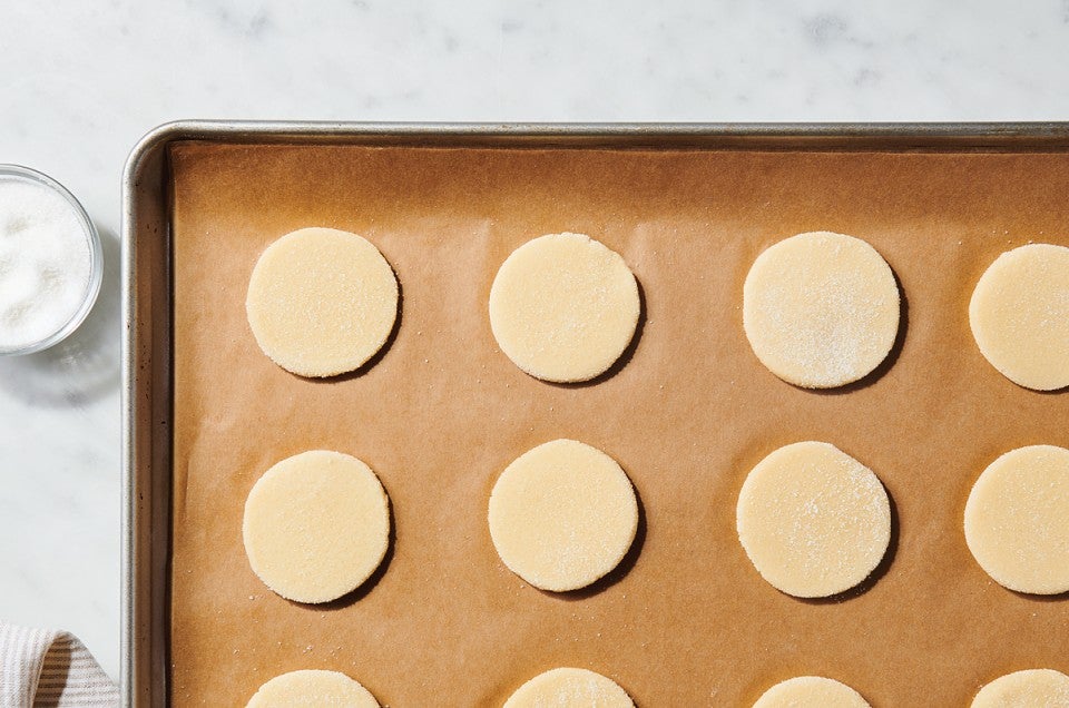 Sugar cookies on parchment-lined baking sheet