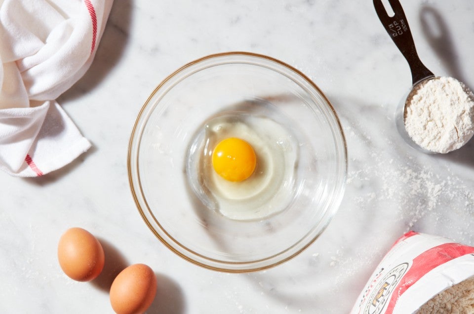 Egg cracked into a clear bowl