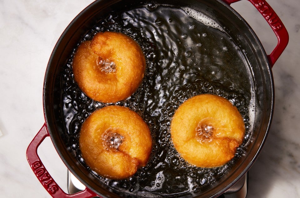 Doughnuts being fried in vegetable oil