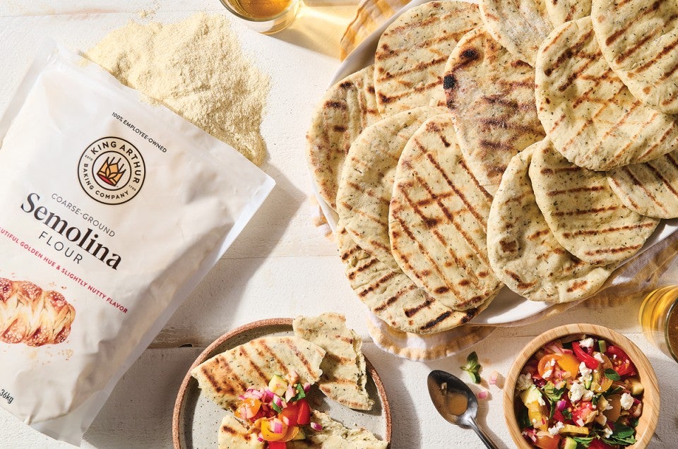 Bag of semolina flour next to grilled Asiago rounds