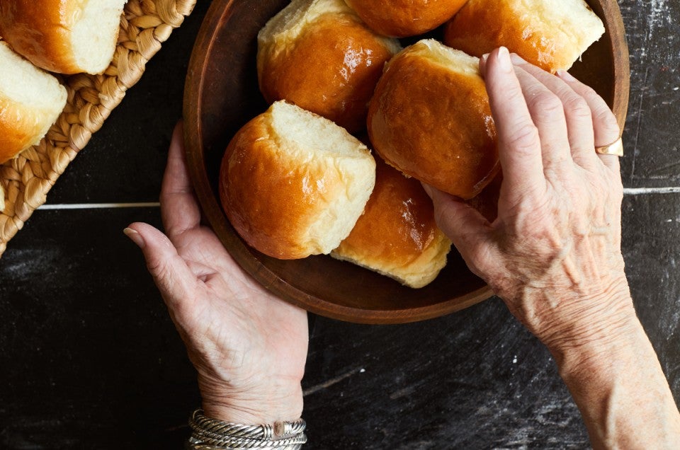 Older hands grabbing bread rolls