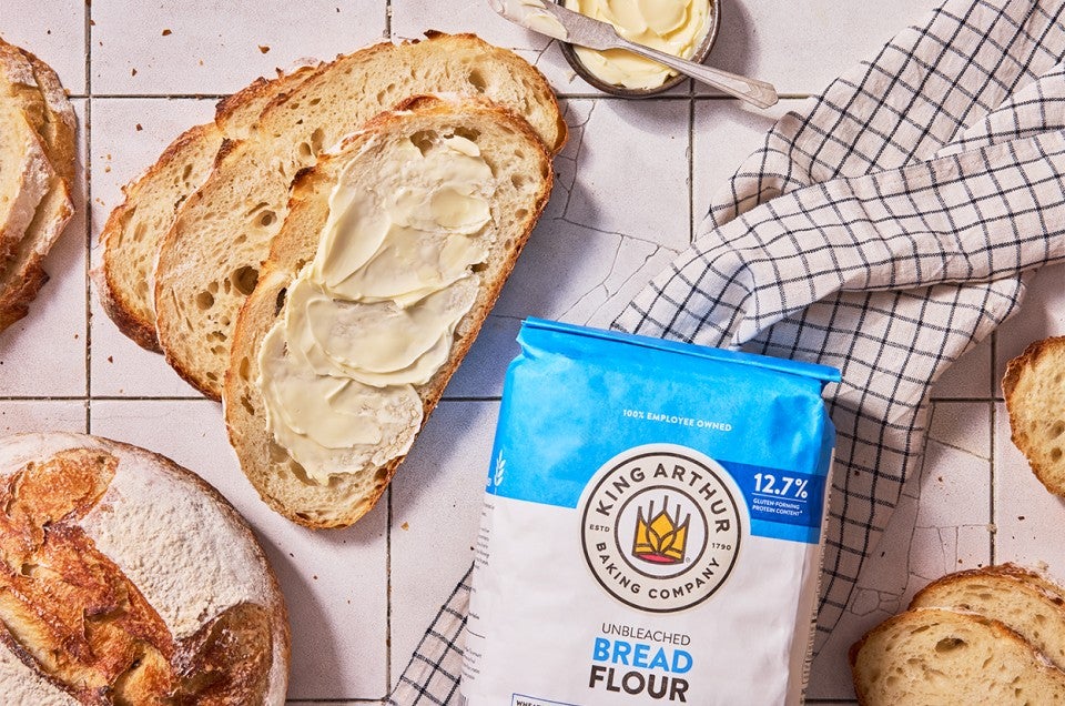 No-Knead Sourdough Bread sliced with butter - select to zoom