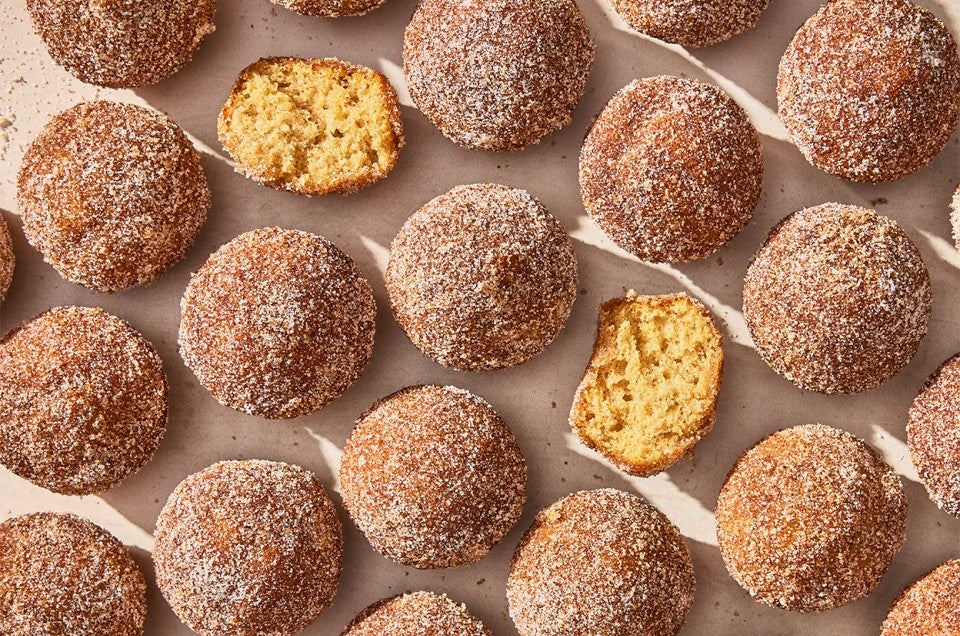 Apple Cider Doughnut Holes laid out on parchment paper - select to zoom