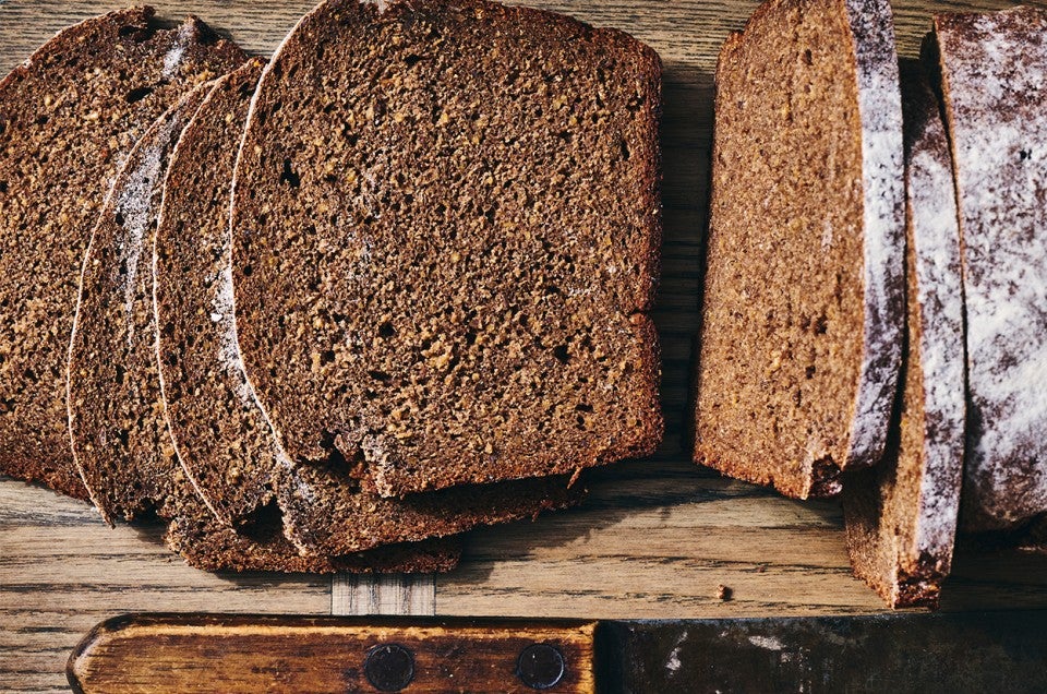 Classic Pumpernickel Bread sliced on a cutting board - select to zoom