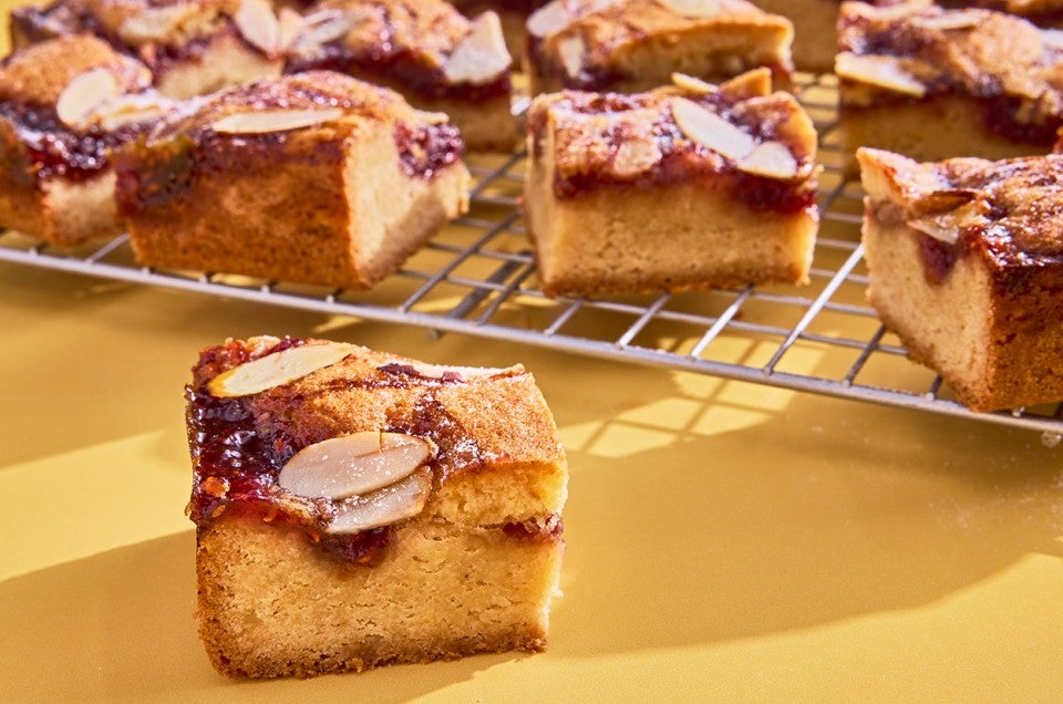 Raspberry Frangipane Bars sliced on a cooling rack - select to zoom