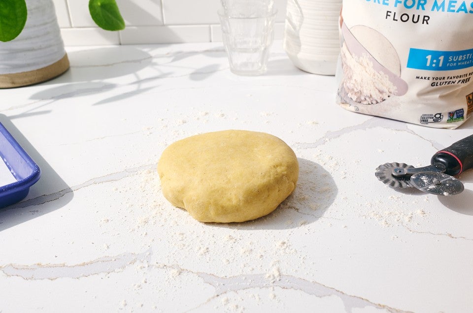 Raw pasta on a counter shaped into a disk ready to be formed. - select to zoom
