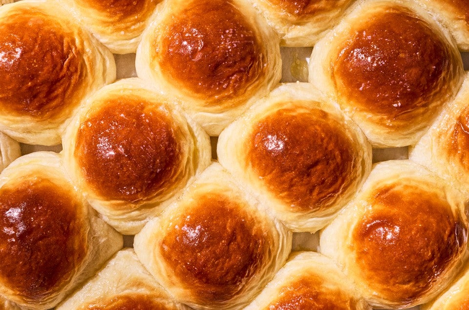 Overhead view of freshly baked dinner rolls on a tray. - select to zoom