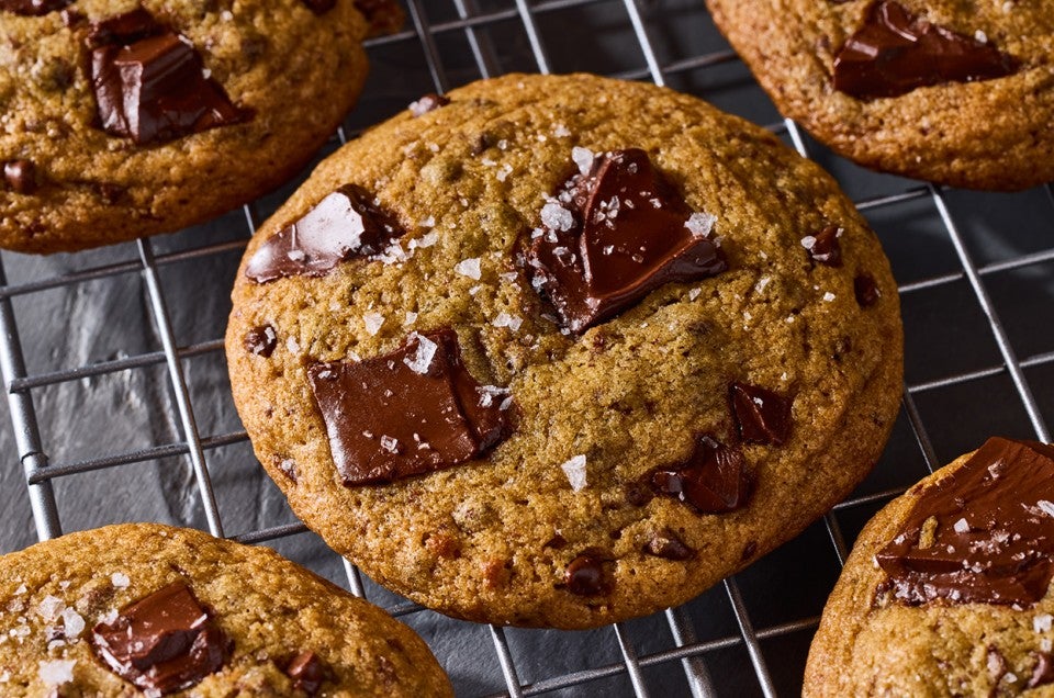 Beautifully baked High-Altitude Chocolate Chip Cookies fresh out of the oven on a cooling rack. - select to zoom