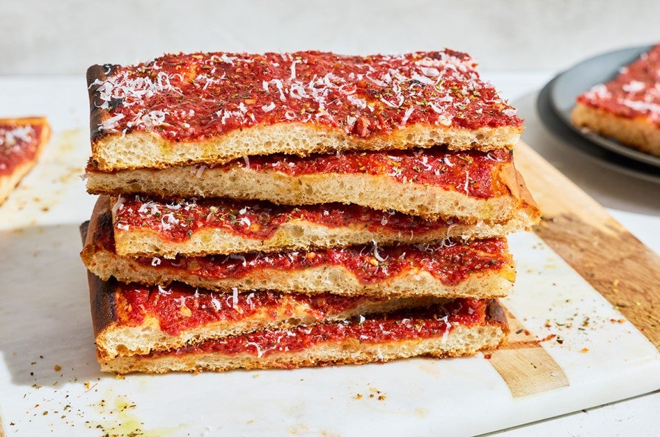 Side photo of a stack of Rhode Island Pizza Strip slices. - select to zoom