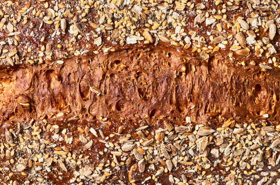 Top view of Multigrain Protein Bread with seeds and a deep brown crust. - select to zoom