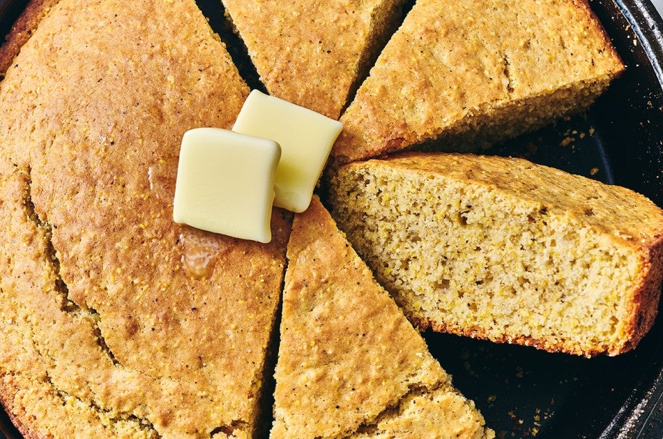Sourdough Cornbread seen from above focused on the golden bread texture and butter dollops. - select to zoom