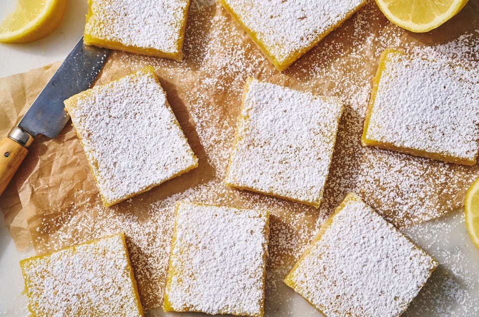 Gluten-Free Lemon Squares with an Almond Flour Crust on parchment paper. - select to zoom