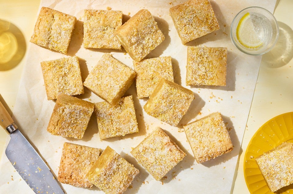 Alex Roberts Lemon Citrus Blondies on parchment paper atop a counter. - select to zoom