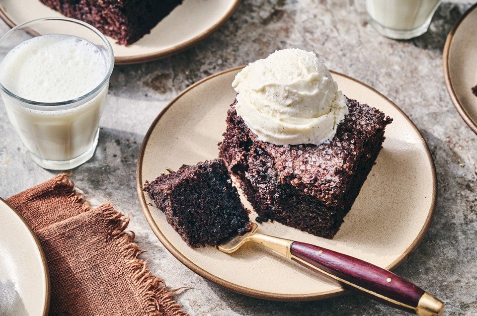 Chocolate Olive Oil Cake topped with vanilla ice cream and a bite on a fork. - select to zoom