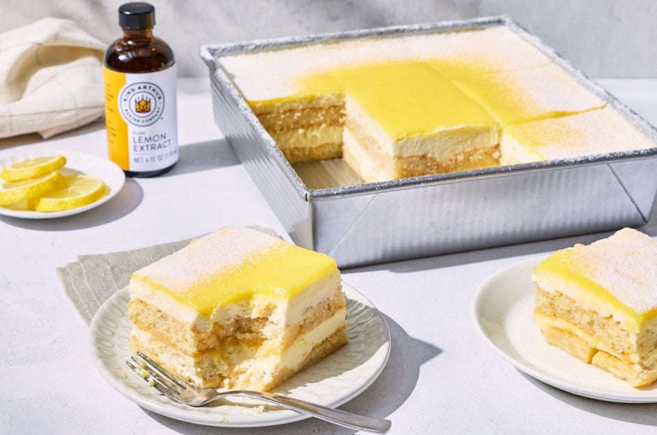 A pan of lemon tiramisu with a few slices removed and a bottle of King Arthur Pure Lemon Extract in the background - select to zoom