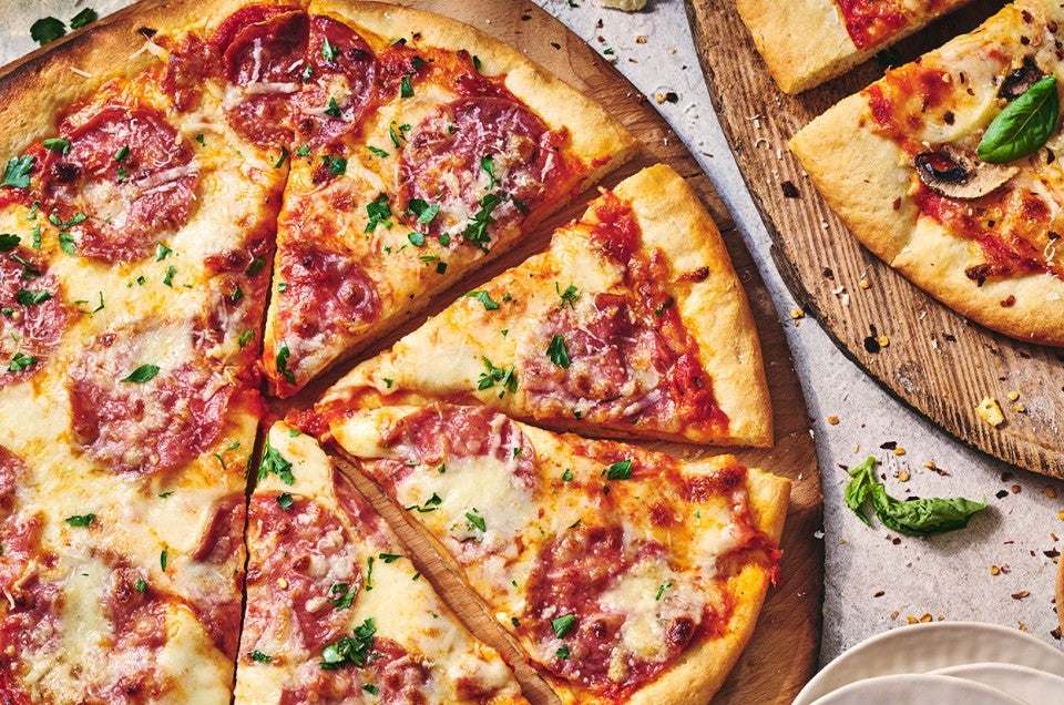 Two pizzas seen from above on wooden pizza peels