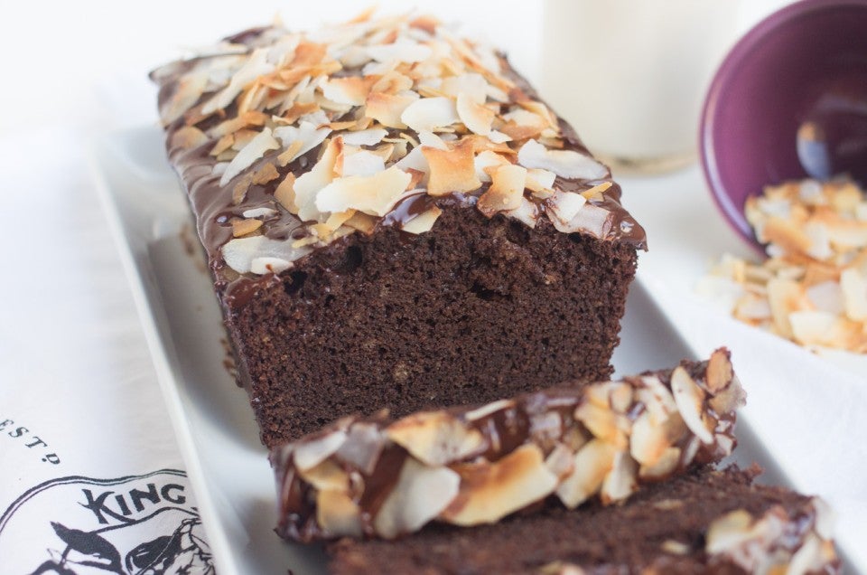 Gluten-Free Coconut Flour Chocolate Cake topped with a Chocolate Glaze and Toasted Coconut Chips