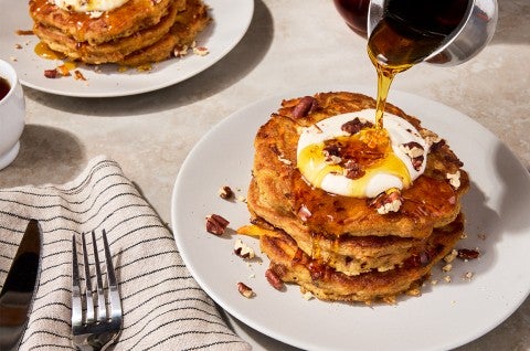 Carrot Cake Pancakes on a plate with syrup pouring over them - select to zoom