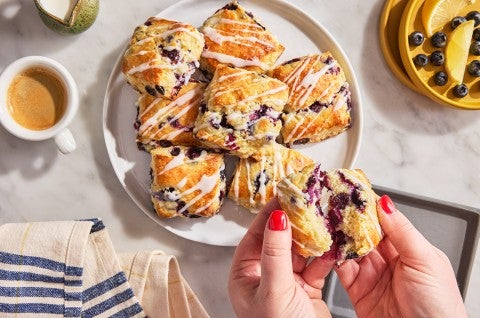 Blueberry Biscuits with Lemon Glaze on a dish with one being broken open - select to zoom