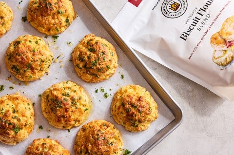 Garlic Cheddar Biscuits on a sheet pan lined with parchment - select to zoom