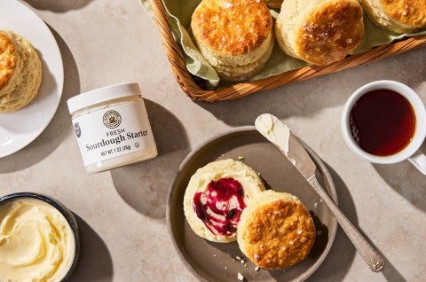 Sourdough Discard Buttermilk Biscuits on a plate with a cup of coffee - select to zoom