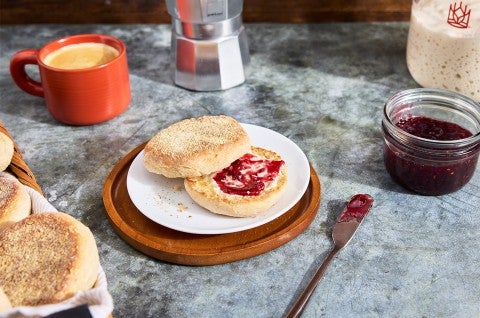 Gluten-Free Sourdough English Muffins made with Bread Flour sliced on a plate with butter and jam - select to zoom
