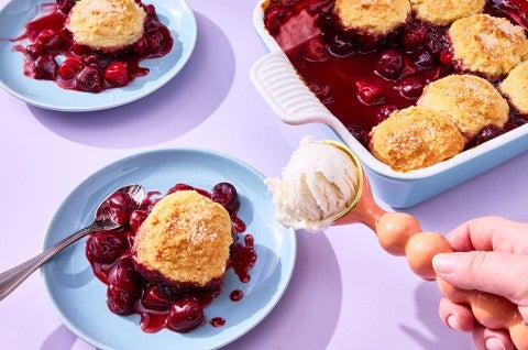 Buttermilk Biscuit Cherry Cobbler on a plate with ice cream being scooped - select to zoom