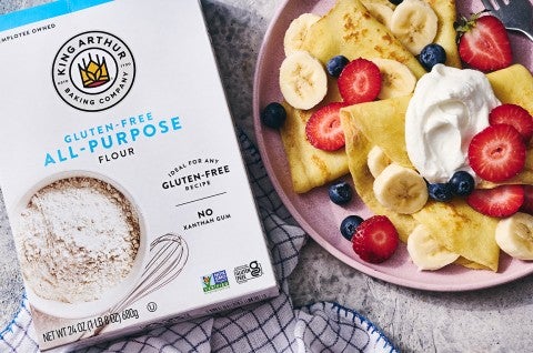 Gluten-Free Crêpes on a plate with berries and cream next to a box of gluten-free flour - select to zoom