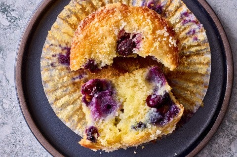 Close up of a broken Lemon Blueberry Muffin on a plate - select to zoom
