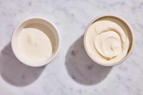 A bowl of leftover heavy cream next to a bowl of creme fraiche