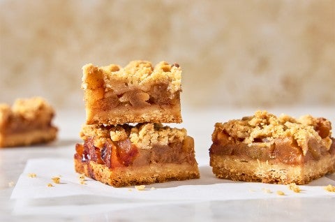Apple Pie Bars stacked up on parchment paper - select to zoom