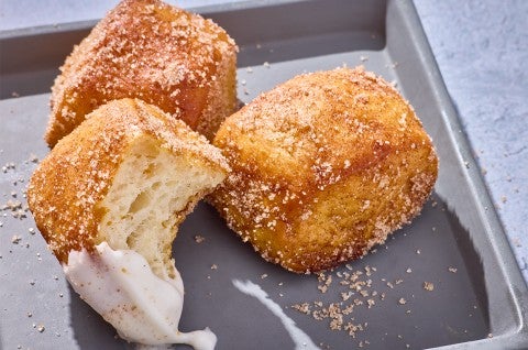 Cinnamon-Sugar Pretzel Bites on a plate, one with a bite out of it - select to zoom