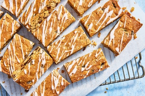 Oatmeal Raisin Cookie Bars sliced up on parchment on a cooling rack - select to zoom