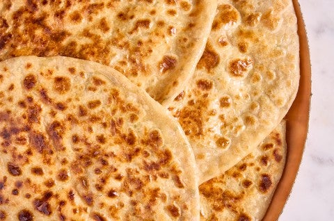 Aloo Paratha (Spiced Potato-Stuffed Flatbread) in a dish - select to zoom