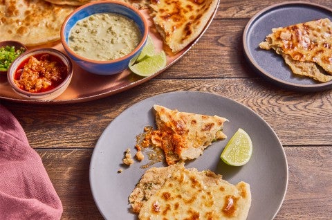 Aloo Paratha (Spiced Potato-Stuffed Flatbread) served on plates - select to zoom