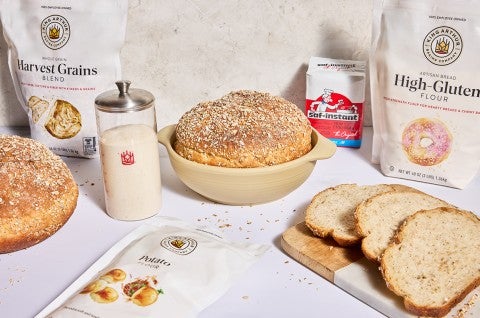 Baker's Grain Sourdough Bread in a boule and also sliced on a cutting board - select to zoom