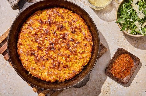 A complete Giant Cheesy Corn Fritter in skillet - select to zoom