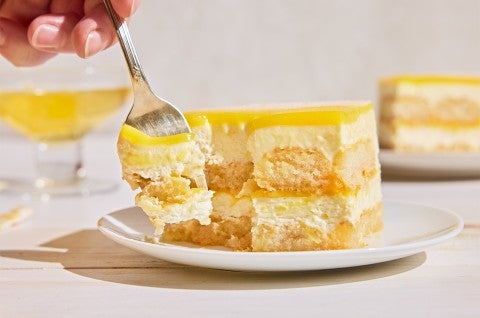 A slice of Lemon Tiramisu on a plate with a fork taking a piece out - select to zoom