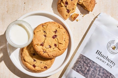 A couple of Peanut Butter and Jelly Cookies on a plate next to a bag of jammy bits - select to zoom